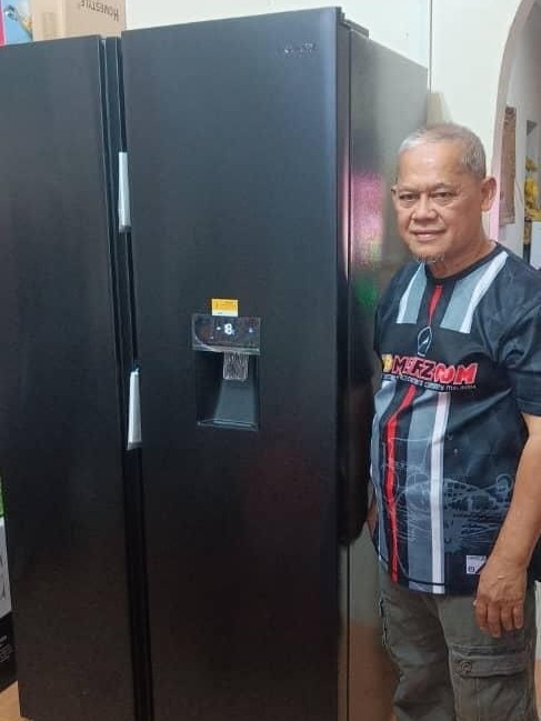 Pelanggan berdiri di sebelah peti sejuk side-by-side Khind