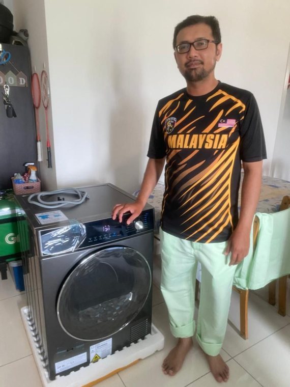 Pelanggan berdiri di sebelah pengering Khind yang baru sampai