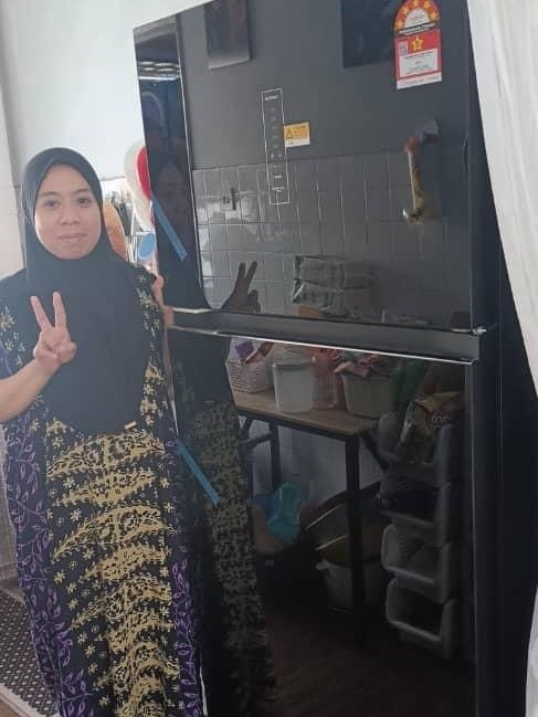 Pelanggan bergaya di sebelah peti sejuk 2 pintu Khind